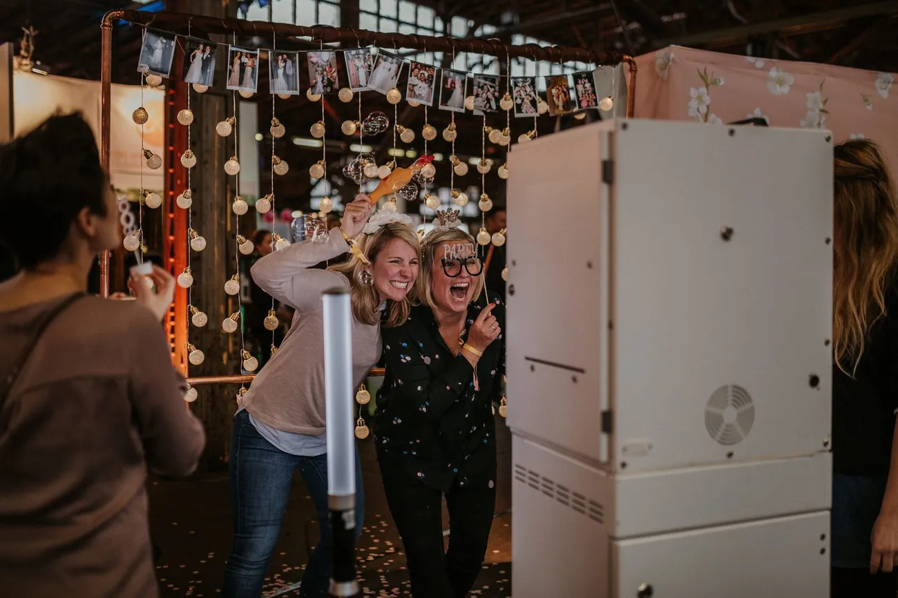 Geschultes Eventpersonal von Cinnamon betreut Gäste an der SNAPSHOT2GO Fotobox auf einer Feier in Berlin